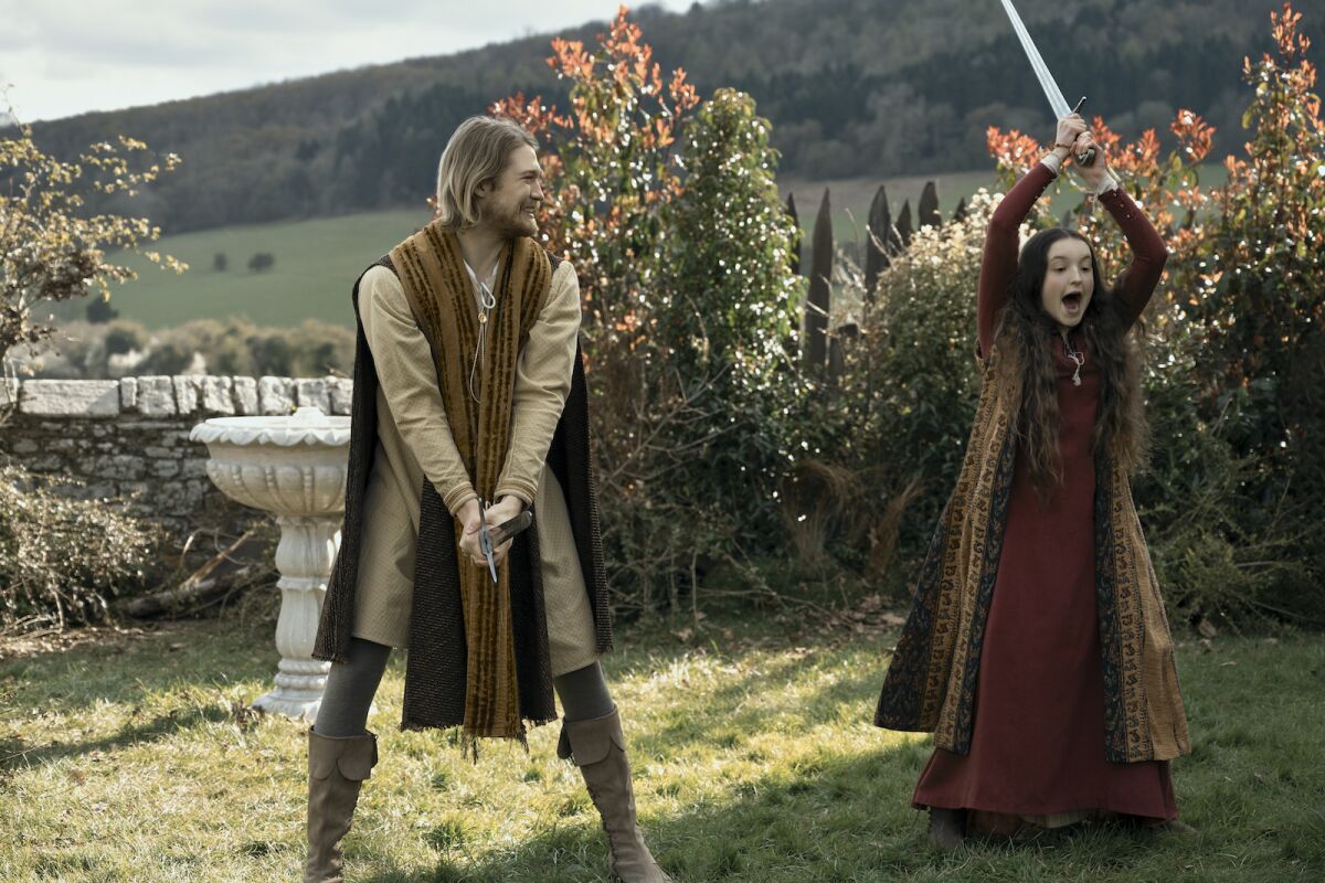 A young man and a teenage girl in 13th century dress wield swords in the movie "Catherine Called Birdy."