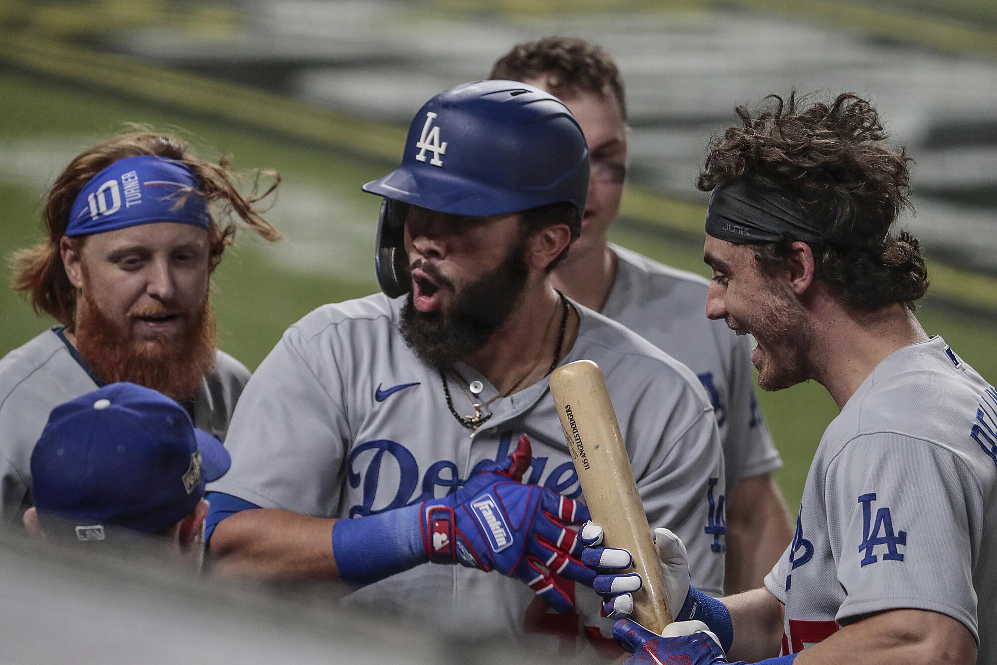 Edwin Ríos celebrates with his Dodgers teammates after hitting a solo home run in Game 4 of the NLCS.