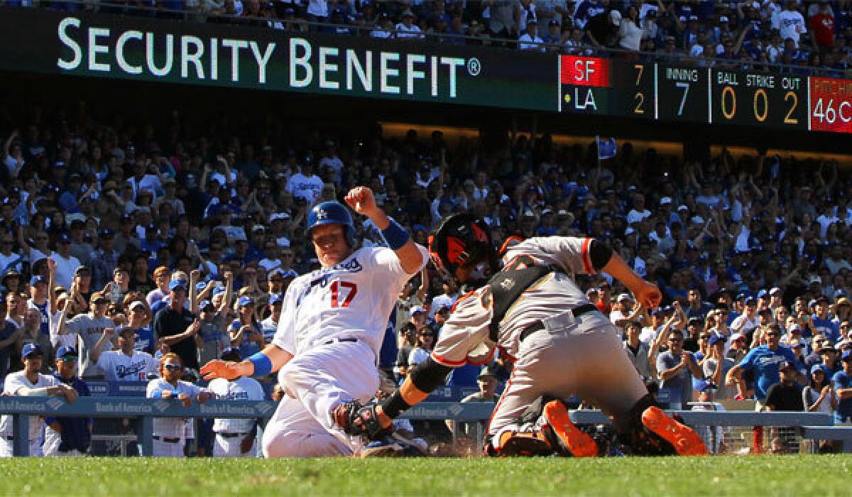 A.J. Ellis is tagged out at the plate by San Francisco catcher Buster Posey during the seventh inning of the Dodgers' 6-2 win on Sunday.