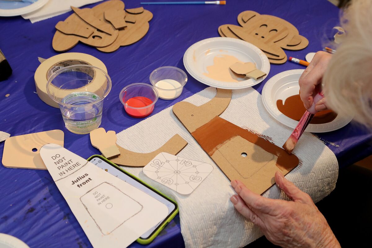 Linda Banks works on her Julius the Monkey clock during a character clock building workshop at Laguna Art Museum.