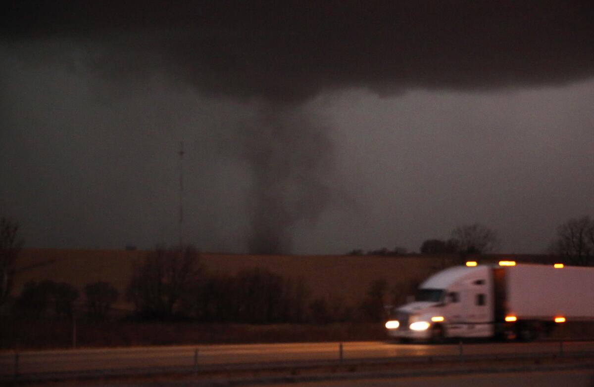 An approaching tornado near a road with a truck on it