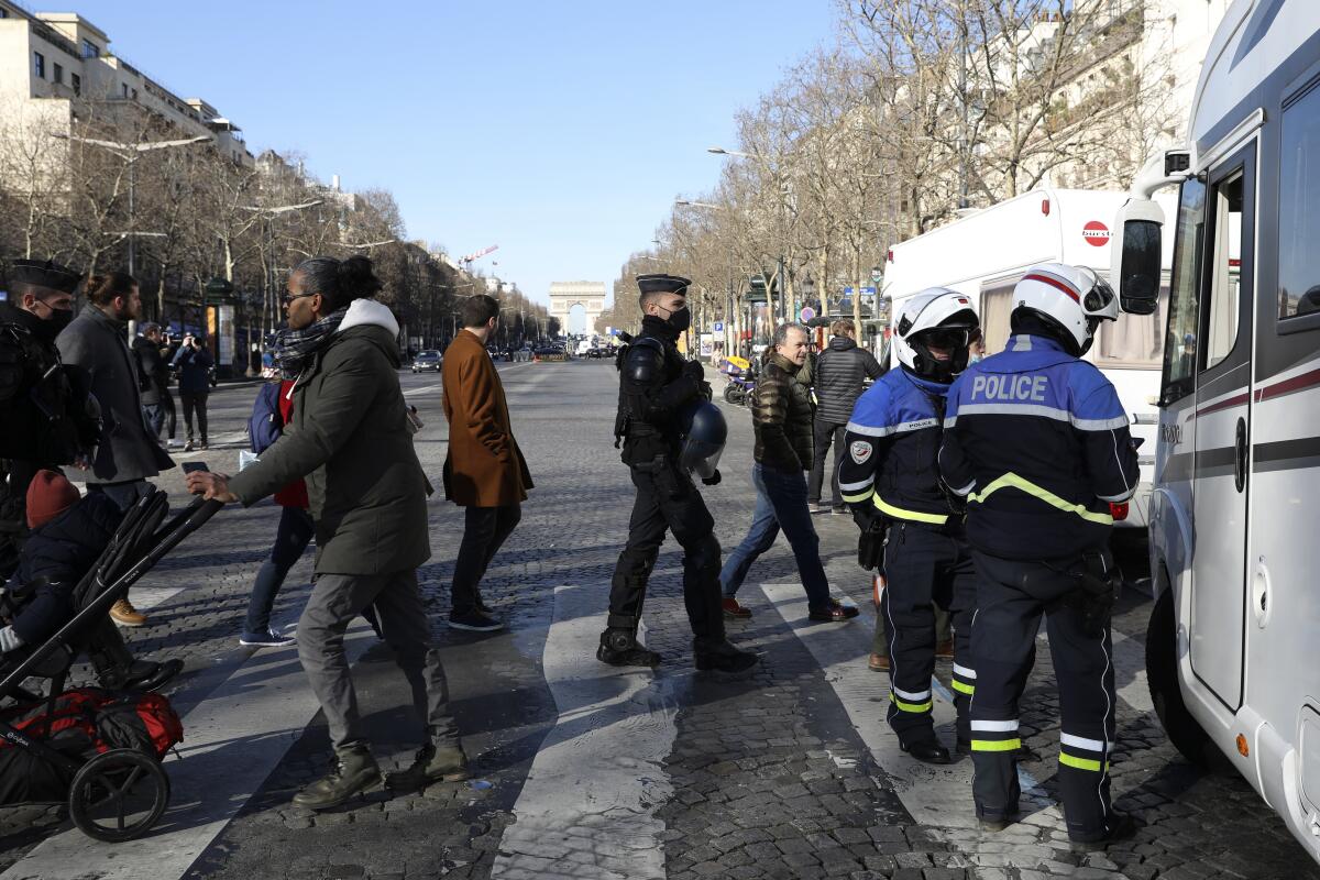 Police in Paris talk to someone in a camper van.