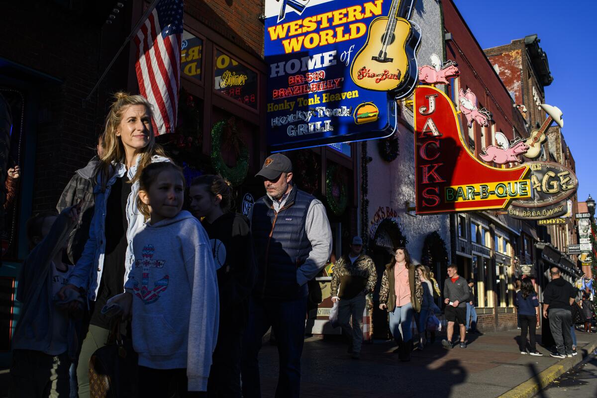 Tourists make their way up and down Broadway in downtown Nashville.