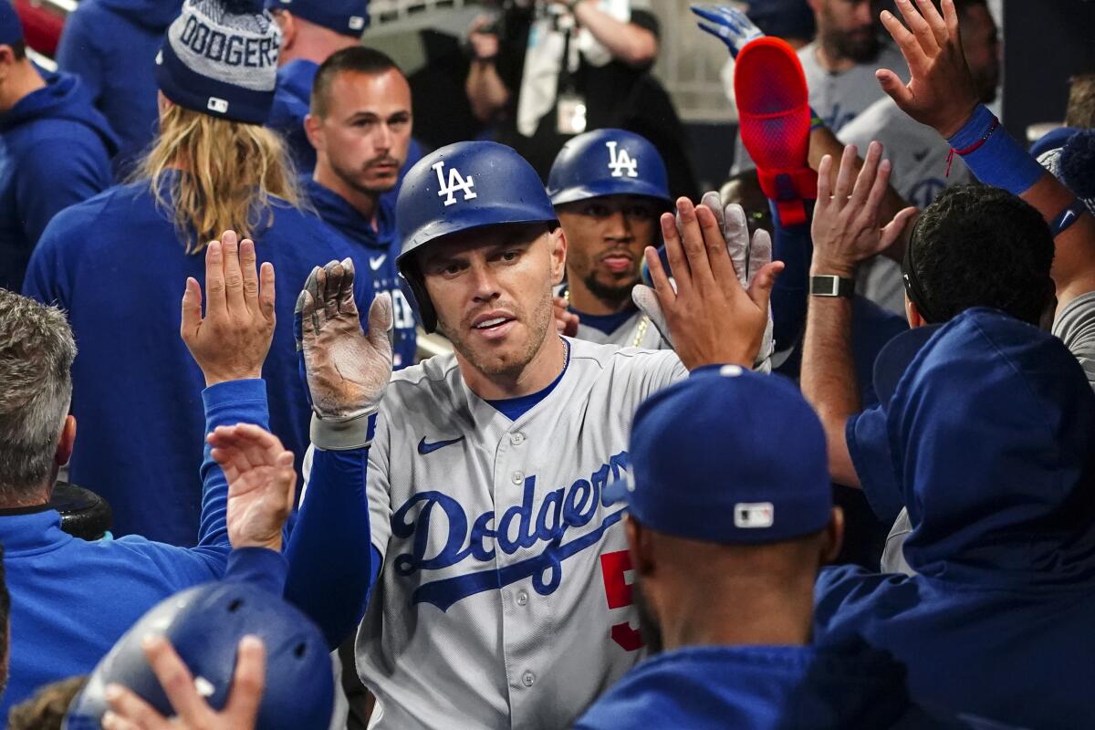 The Dodgers' Freddie Freeman celebrates in the dugout after hitting a three-run home run.