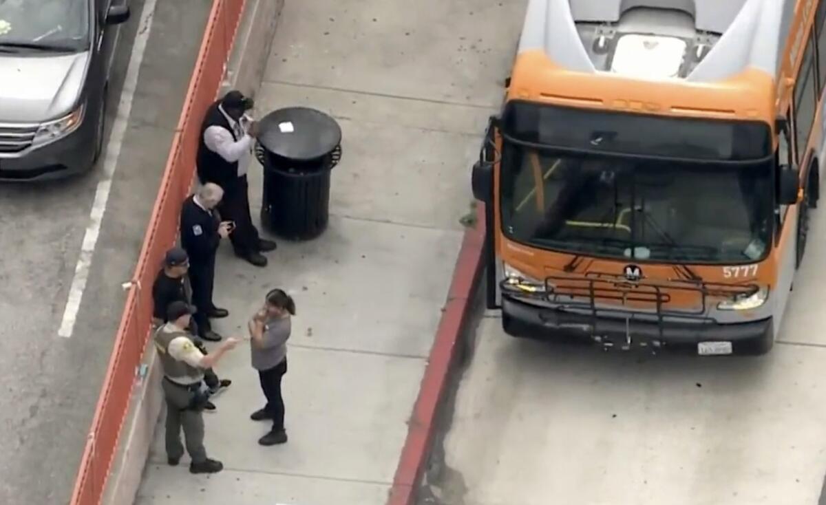 A view from above of people standing next to a bus.
