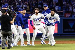 LOS ANGELES, CA - JULY 2, 2024: Teammates swarm Los Angeles Dodgers outfielder Teoscar Hernandez (37) after he hit a walk-off single to give the Dodgers a 6-5 win over the Arizona Diamondbacks in the ninth inning at Dodgers Stadium on July 2, 2024 inLos Angeles, California.(Gina Ferazzi / Los Angeles Times)