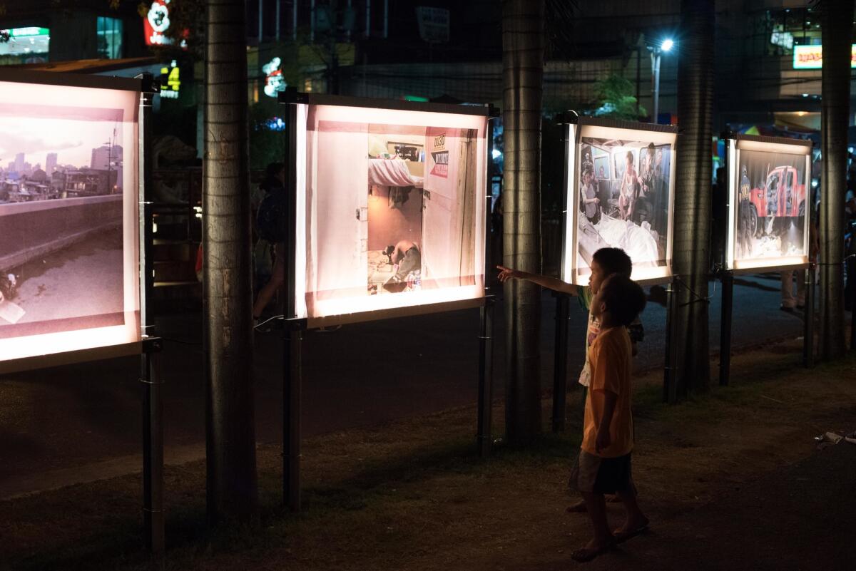 Boys look at pictures of those killed during the drug war in an exhibit outside a church Dec. 23 in Manila.