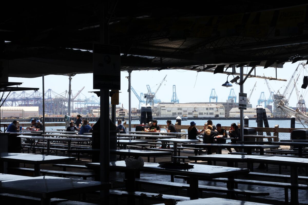 People eat outside on the dock at the San Pedro Fish Market