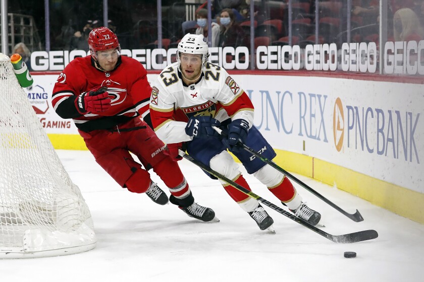 Florida Panthers' Carter Verhaeghe (23) is chased by Carolina Hurricanes' Brett Pesce (22) during the third period of an NHL hockey game in Raleigh, N.C., Tuesday, April 6, 2021. (AP Photo/Karl B DeBlaker)