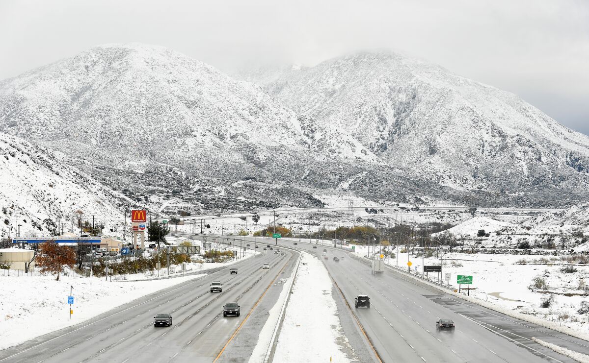 Snow covers the mountains along the 15 Freeway at the Cajon Pass on Thursday afternoon.