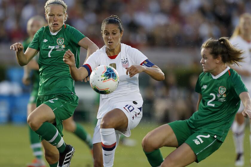 PASADENA, CALIF. - AUG. 3, 2019. USA forward Carli Lloyd tries to split the defense of Ireland's Diane Caldwell, left, and Heather Payne in the first half Saturday night, Aug. 3, 2019, at the Rose Bowl in Pasadena. (Luis Sinco/Los Angeles Times)