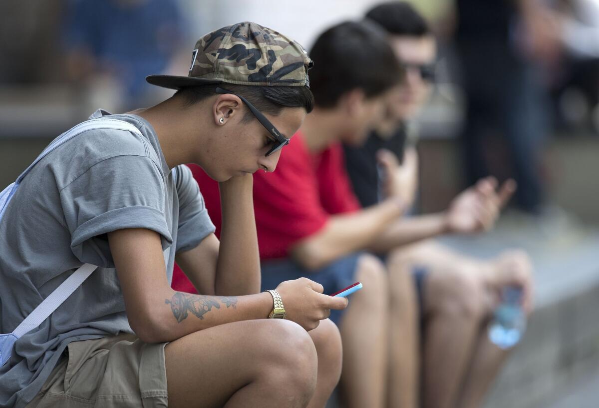 A youth checks his cell phone in Sao Paulo, Brazil, on Dec. 17.