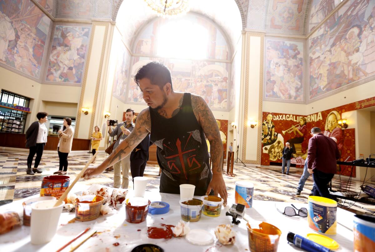 Artist Dario Canul of Tlacolulokos working on the murals in the L.A. Central Library.