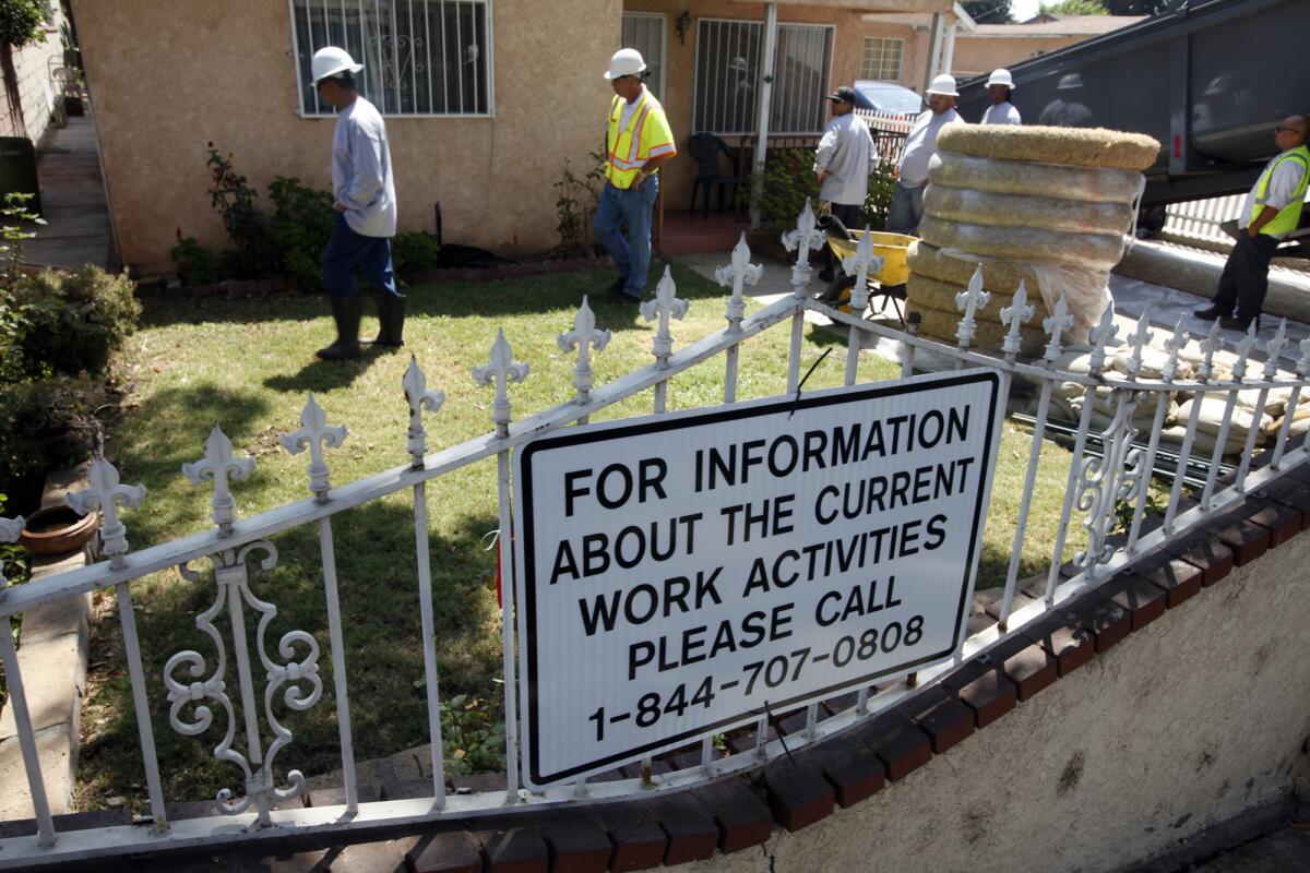 Crews hired by Exide Technologies began work Monday to remove lead-contaminated soil from two homes in Boyle Heights under orders from California toxic waste regulators.