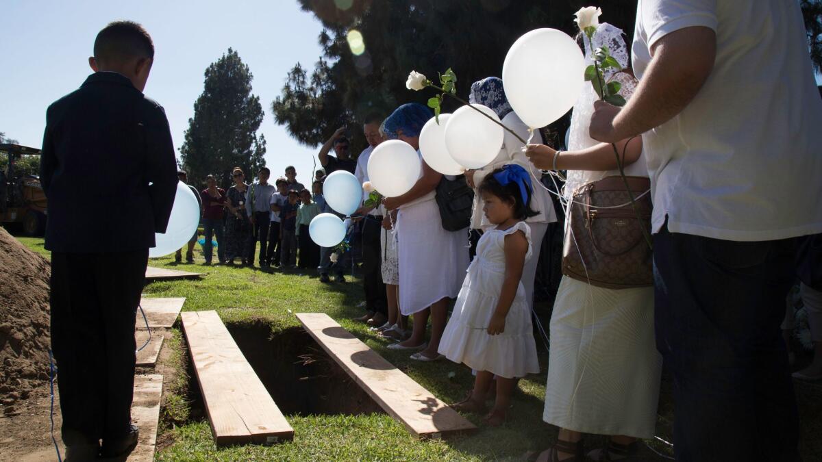 Family and friends of Moises Murillo gather at Oakdale Memorial Park for his burial service.