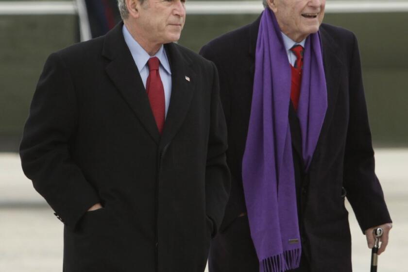 Private photos of presidents George W. Bush, left, and his father George H.W. Bush were hacked and put online.