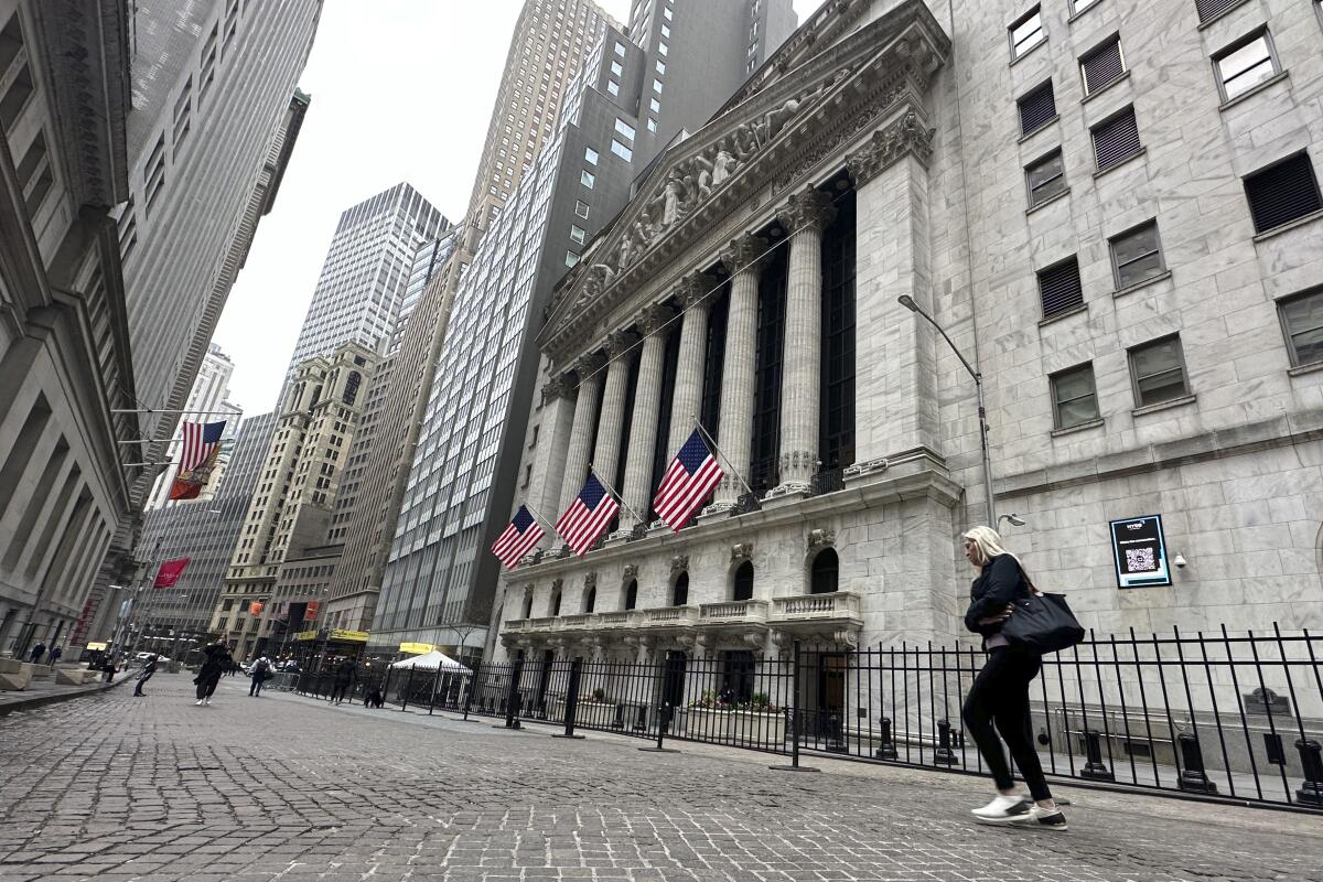 A pedestrian walks past the New York Stock Exchange on Tuesday