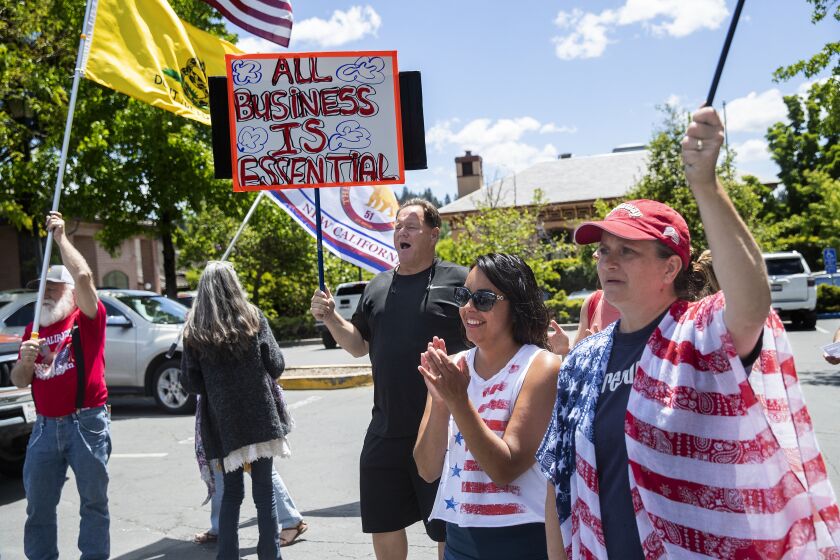 GRASS VALLEY, MAY 22, 2020: Jerry O'Brien, of Placer County, holding sign, joins other demonstrators outside Grass Valley City Hall, in a rally, protesting California's stay at home order. O'Brien said that his daughter owns a small business in Grass Valley. (Mel Melcon/Los Angeles Times)