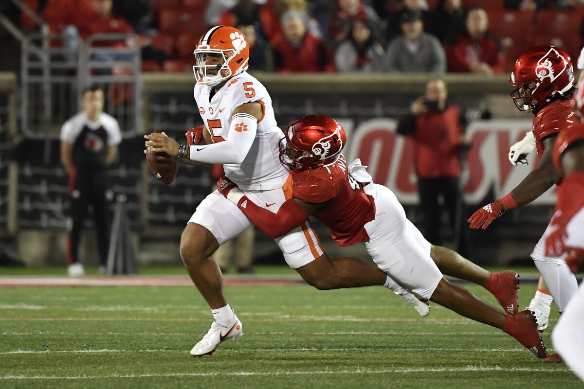 Clemson quarterback D.J. Uiagalelei (5) is tackled by Louisville linebacker C.J. Avery (9) during the first half of an NCAA college football game in Louisville, Ky., Saturday, Nov. 6, 2021. (AP Photo/Timothy D. Easley)