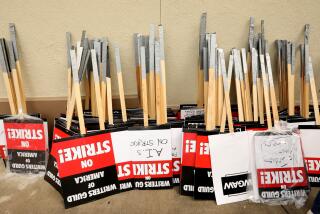 Los Angeles, California-May 4, 2023-Signs stand ready for picketers on day three of the Writers Guild of America strike, a large group of WGA members picket in front of Paramount Studio gate in Los Angeles, California on May 4, 2023. (Carolyn Cole / Los Angeles Times)