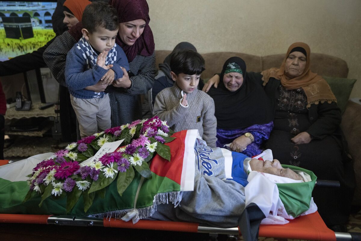 Mourners take a last look at the body of Omar Asaad, 80, in the family house, during his funeral in the West Bank village of Jiljiliya, north of Ramallah, Thursday, Jan. 13, 2022. Israel is investigating after Asaad, a Palestinian with U.S. citizenship, died of a heart attack after being detained by Israeli soldiers in the occupied West Bank. (AP Photo/Nasser Nasser)