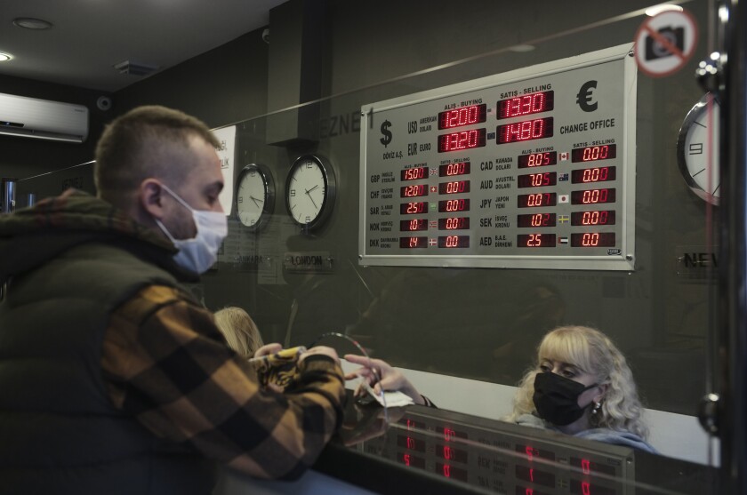 FILE - A man changes Turkish lira for USD and Euro at a currency exchange shop, in Ankara, Turkey, Tuesday, Nov. 23, 2021. Annual inflation in Turkey soared to nearly 80% in July. The Turkish Statistical Institute said Wednesday Aug. 3, 2022 that consumer prices rose by 79.6% from a year earlier, up about 1 percentage point from June data. (AP Photo/Burhan Ozbilici, File)