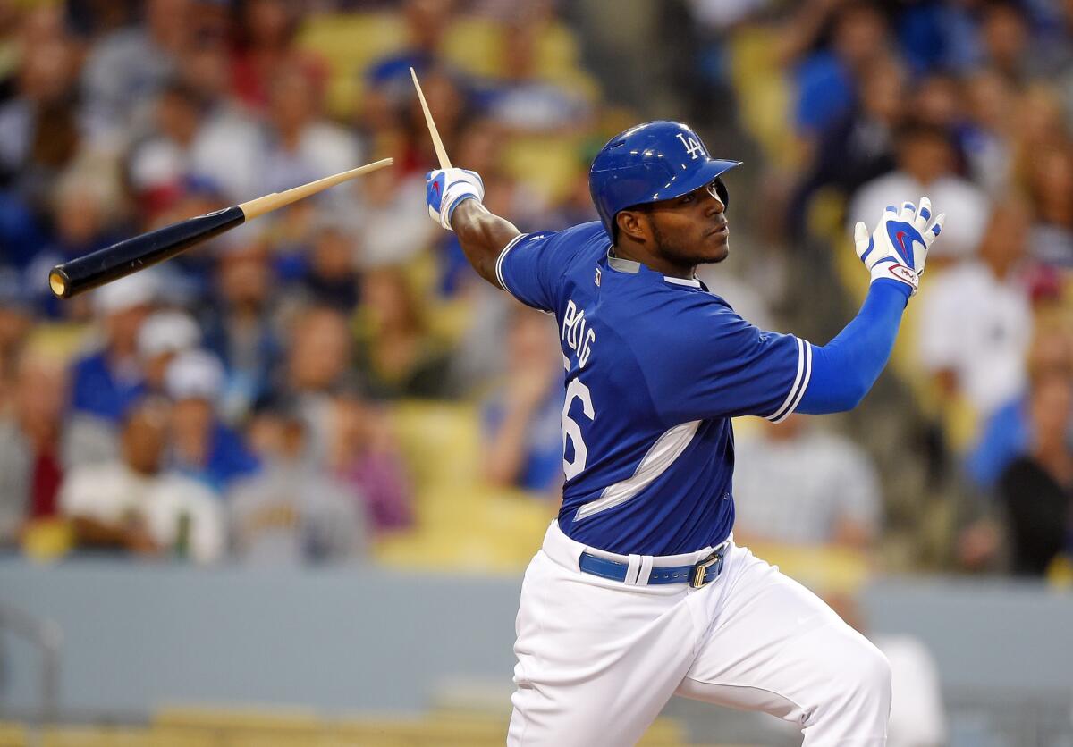 Los Angeles Dodgers' Yasiel Puig breaks his bat as he singles during the fourth inning of a preseason Major League Baseball game against the Los Angeles Angels on Saturday in Los Angeles.