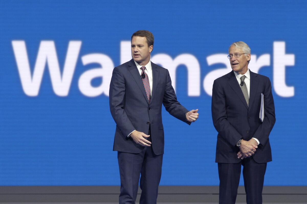 Wal-Mart CEO Doug McMillon, left, with outgoing board chairman Rob Walton at the Wal-Mart shareholder meeting in Fayetteville, Ark.