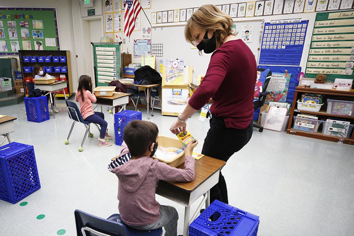 Kindergarten teacher Jennifer Klein collects crayons from students.