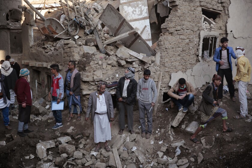 People gather at the site of a Saudi-led airstrike near Yemen's Defense Ministry complex 
