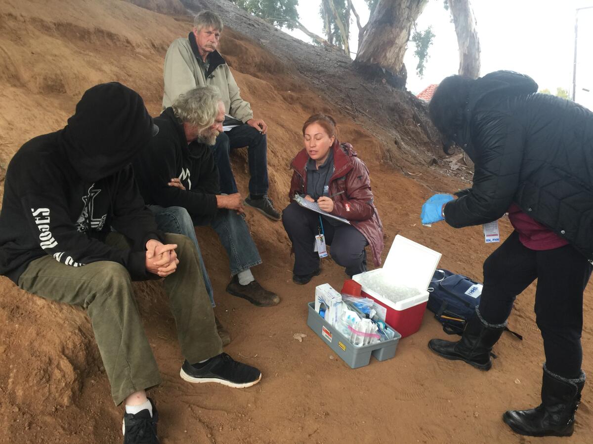 San Diego County public health nurse Aracely Ruvalcaba talks with homeless men.