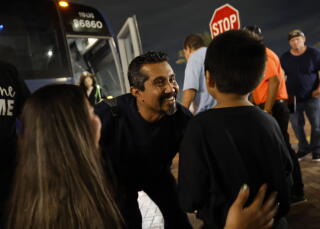 Angel Rodrigo Minguela Palacios greets his son and wife after arriving at Union Station in a Greyhound bus from Phoenix