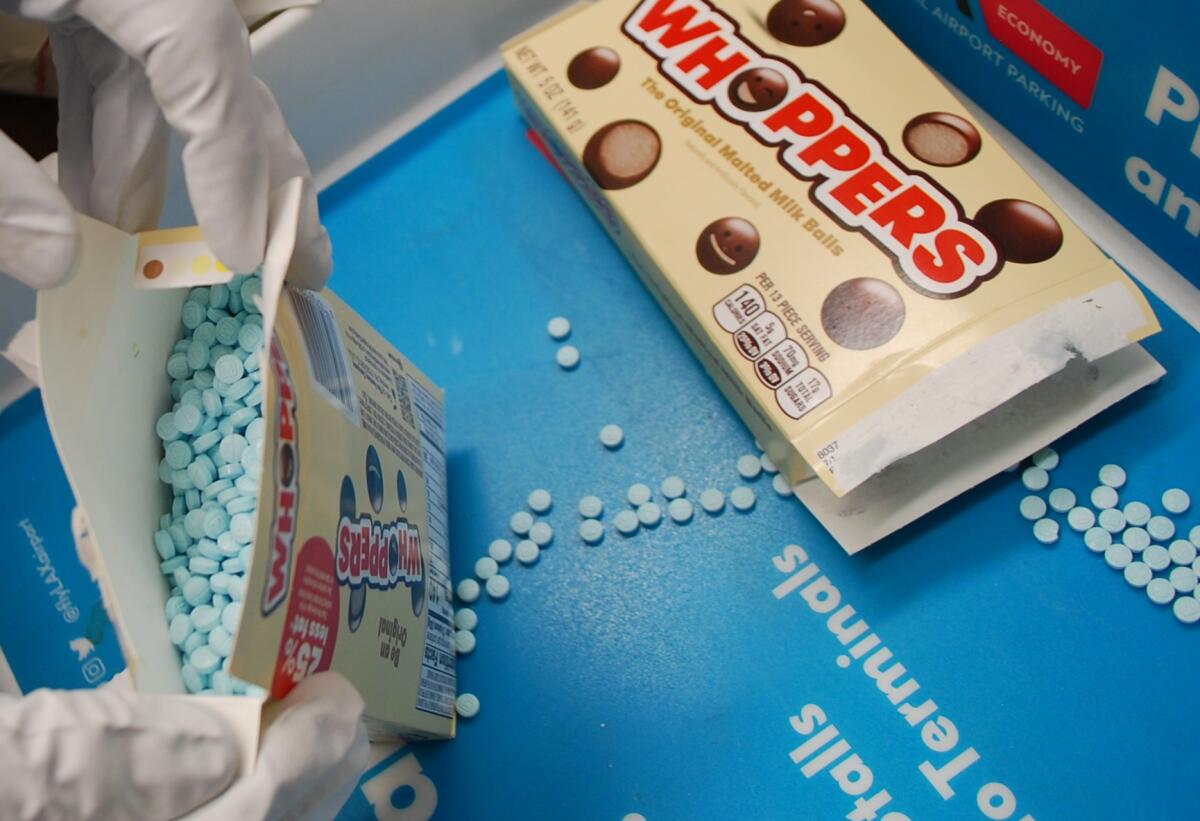 A box of Whoppers with round blue pills instead of candy inside