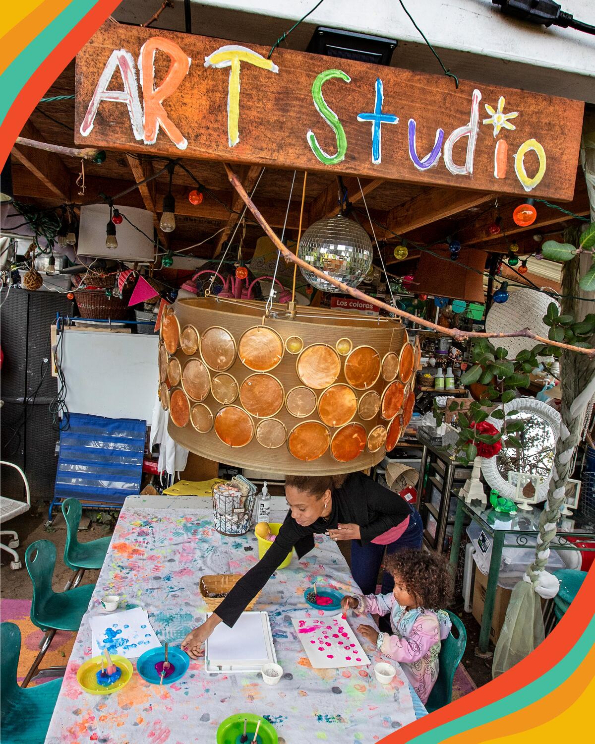 A woman and her daughter paint together in an art studio