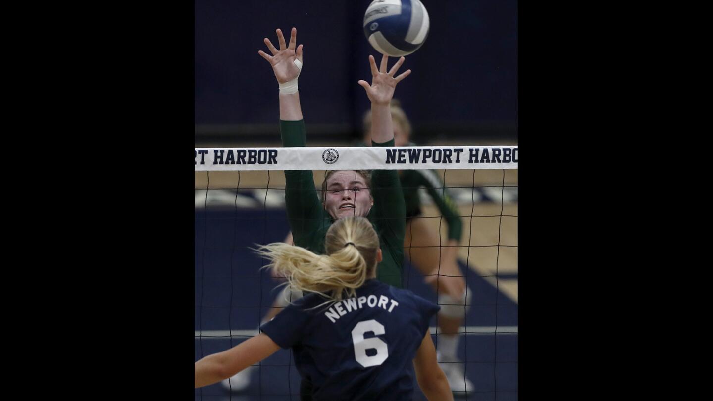 Edison High's Taylor Torch blocks a shot by Newport Harbor's Gabbi Higgs (6) during the first set in a Sunset League match in Newport Beach on Thursday, Sept. 13.