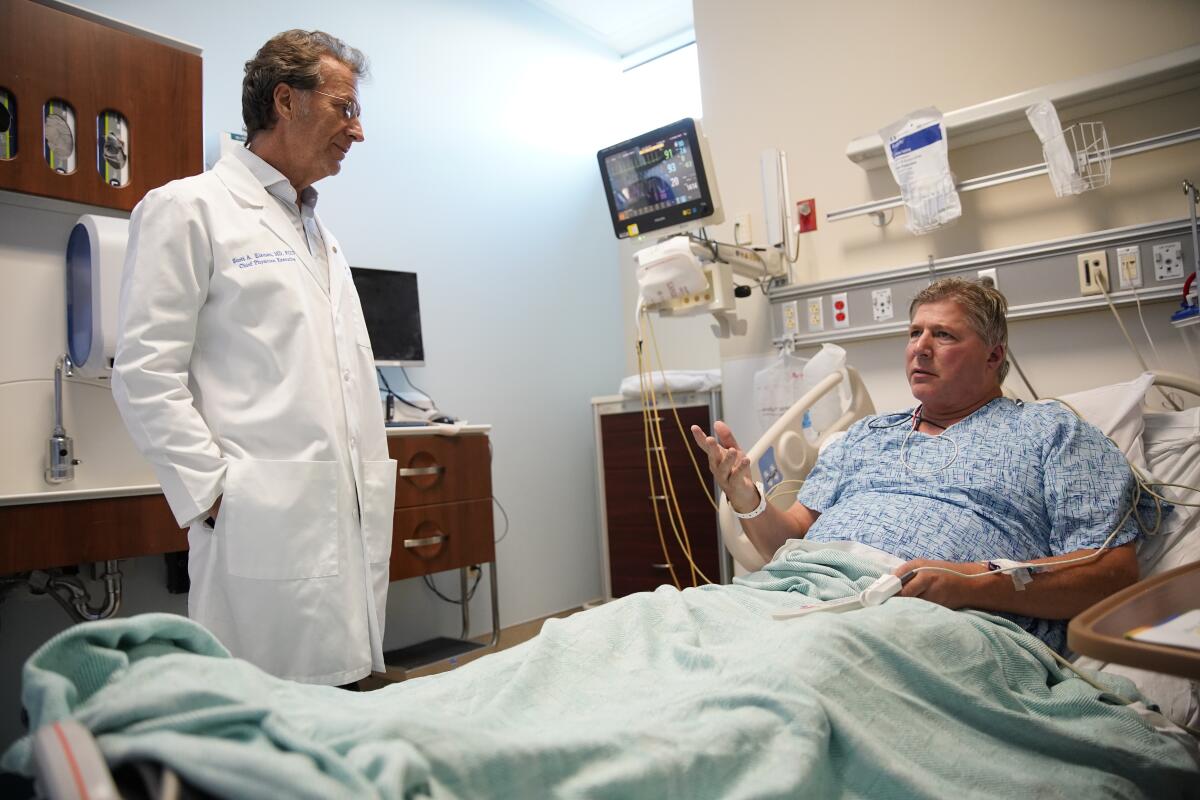 Dr. Scott Eisman, chief physician executive at Scripps Memorial Hospital Encinitas, talks with boarded patient Aaron DeLaby