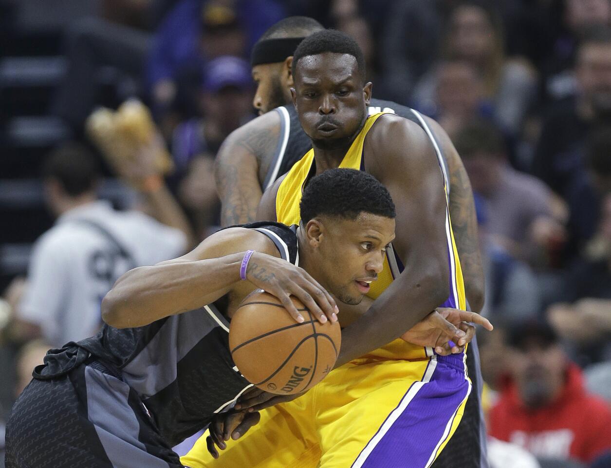 Kings forward Rudy Gay, left, tries to drive past Lakers forward Luol Deng during the first quarter.