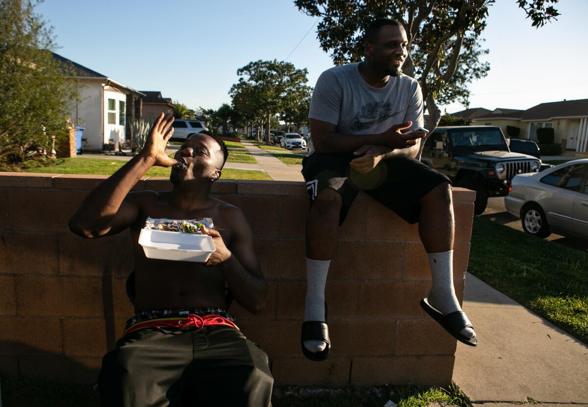 Lucius Johnson, left, enjoys his shrimp tacos while Davonte Gilmore waits for his order at Munchie Madness in Compton.