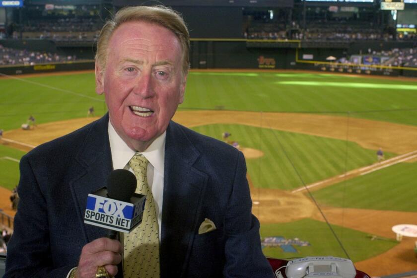 FILE - In this July 3, 2002, file photo, Los Angeles Dodgers television play-by-play announcer Vin Scully rehearses before a game between the Dodgers and the Arizona Diamondbacks, in Phoenix. Vin Scully will receive the Icon Award at The ESPYS, with actor Bryan Cranston presenting the honor given to those whose careers have left a lasting impression on the sports world. Scully retired last fall after 67 years calling Los Angeles Dodgers games. (AP Photo/Paul Connors, File)