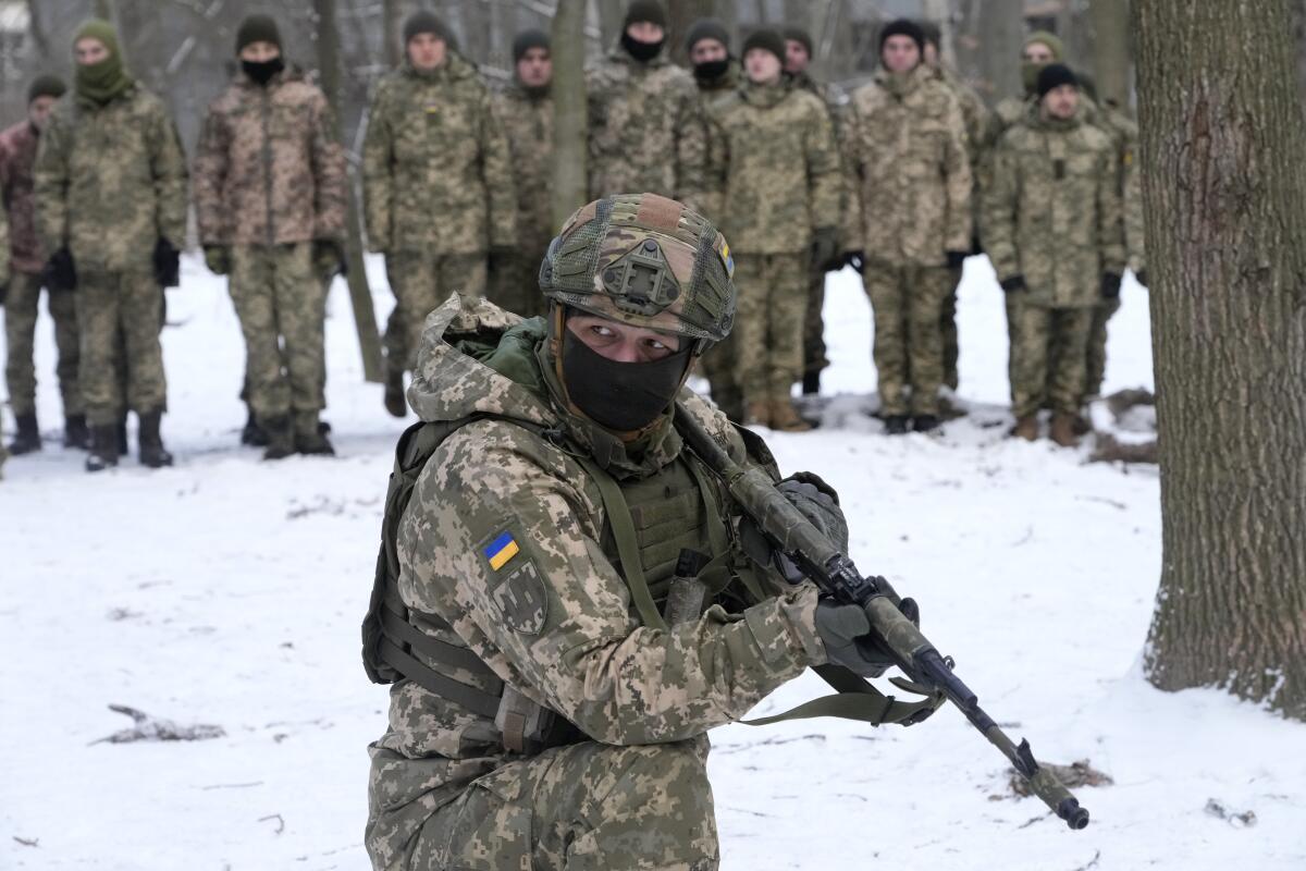 Un instructor capacita a miembros de las fuerzas de defensa de Ucrania, en un parque de Kiev