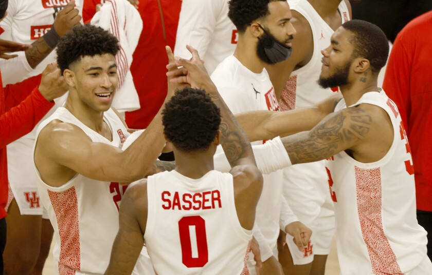 Houston's Quentin Grimes (24), Marcus Sasser (0) and Fabian White Jr. (35) celebrate following the team's win over Memphis in an NCAA college basketball game in the semifinal round of the American Athletic Conference men's tournament Saturday, March 13, 2021, in Fort Worth, Texas. (AP Photo/Ron Jenkins)