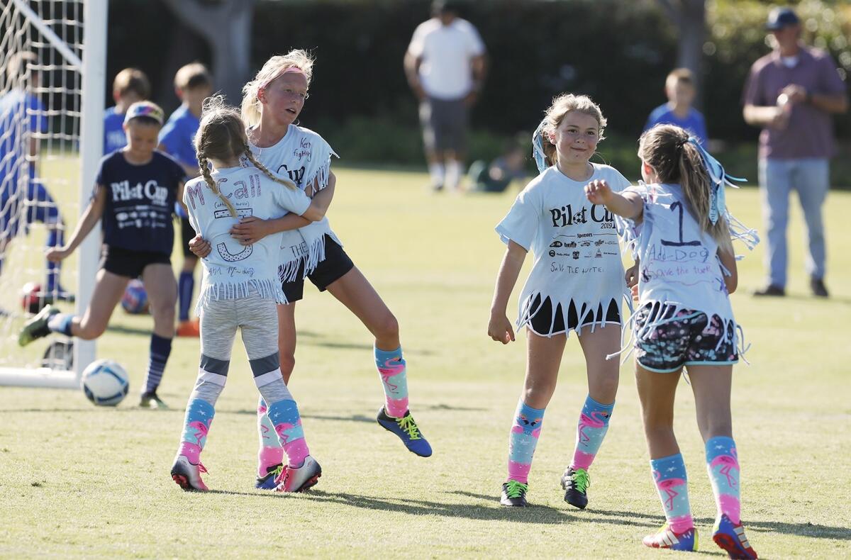 Andersen Elementary's McCall Whitmer, left, celebrates with Ella Olson, second to left, after Olson scored a goal in a girls' third- and fourth-grade Gold Division pool-play match against Mariners at the Daily Pilot Cup on Wednesday.