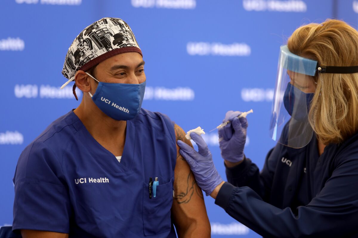 Erik Mara, a respiratory therapist at UCI Health, gets a COVID-19 vaccine  in Orange