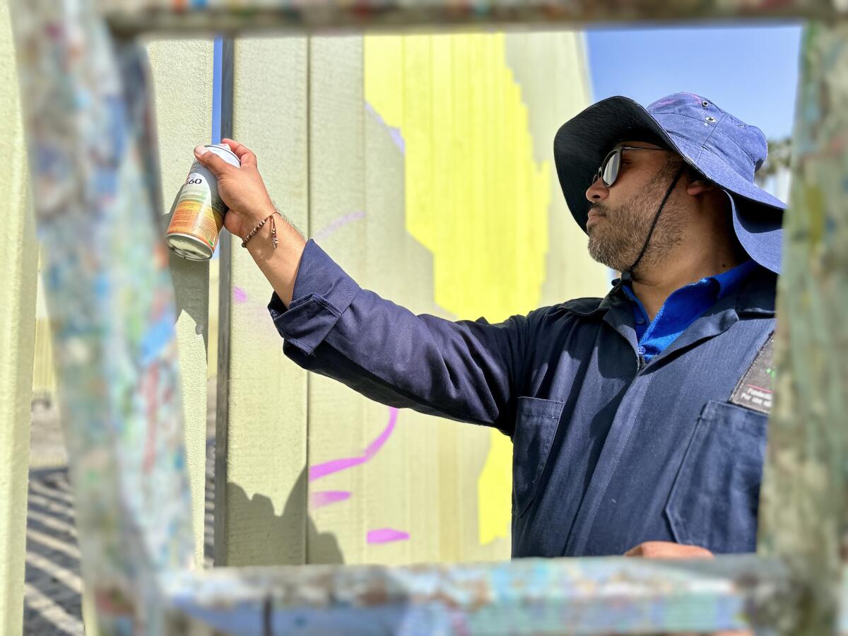 El artista Enrique Chiu empieza a pintar un mural 