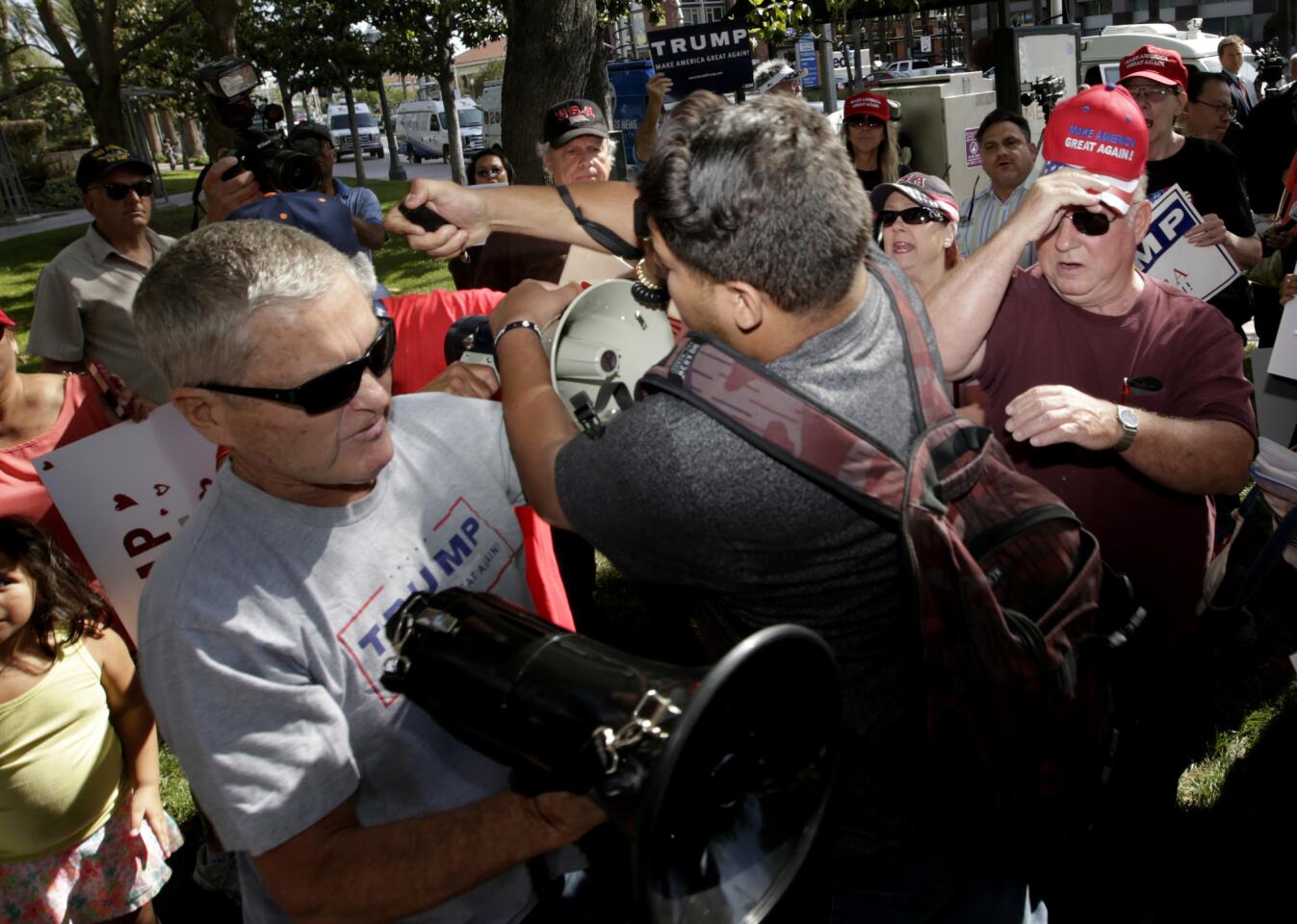 An anti-Donald Trump protestor, center, pepper sprays a crowd of Trump supporters outside Anaheim City Hall.