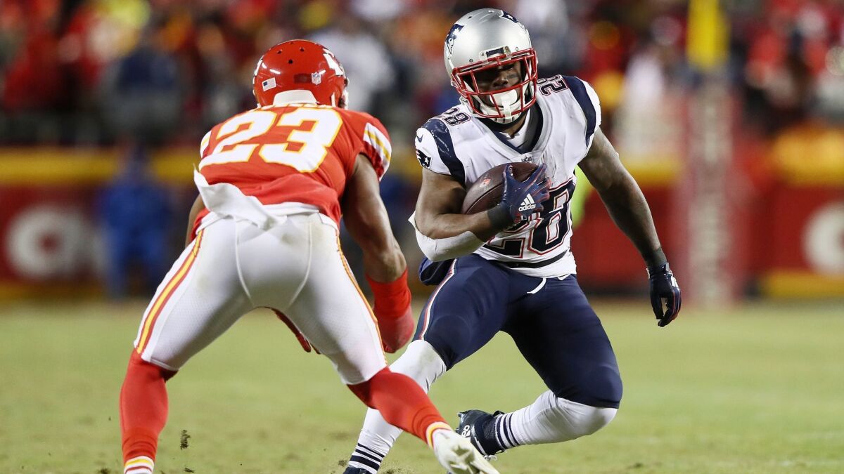 New England Patriots running back James White runs with the ball in front of Kansas City Chiefs defensive back Kendall Fuller during the AFC championship game.