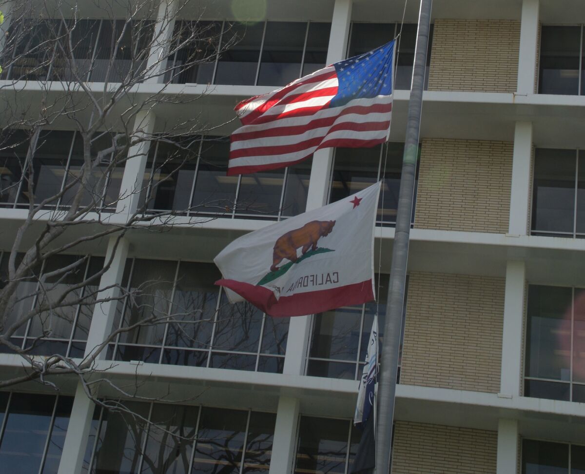 U.S. and California flags flying outside Costa Mesa City Hall
