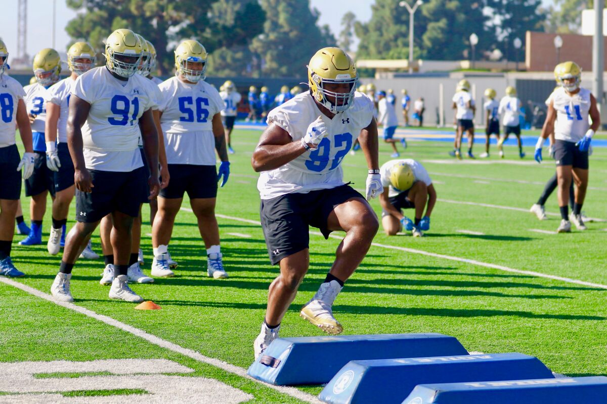 UCLA junior defensive lineman Osa Odighizuwa participates in an agility drill during a team practice session Tuesday.
