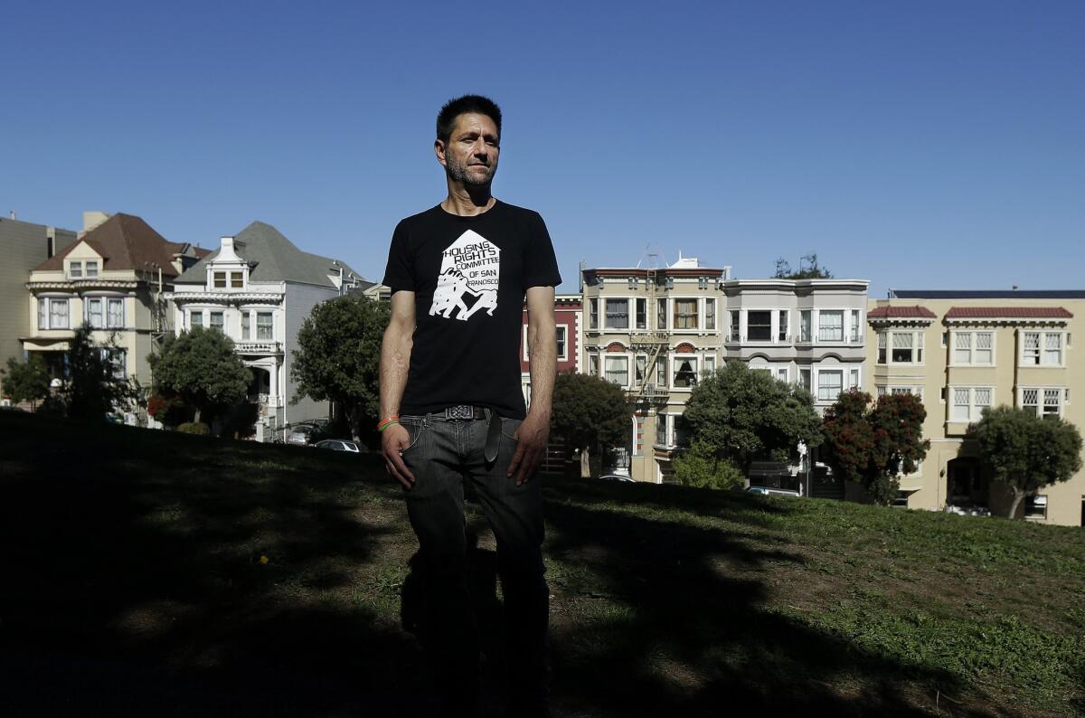 San Francisco resident Michael Rouppet stands in Alamo Square Park, across the street from the home from which he was evicted. (AP Photo/Jeff Chiu)