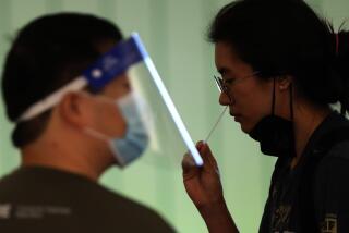 LOS ANGELES, CA - DECEMBER 3, 2021 - An arriving traveler takes a free COVID-19 Rapid Test under the direction of a CORE worker at the Tom Bradley International Terminal at Los Angeles International Airport Friday, December 3, 2021. In partnership with the state and U.S. Centers for Disease Control and Prevention, the county set up a free rapid testing site for arriving passengers. They were also gave those testing negative a kit they can use to test themselves again three to five days later, in line with CDC recommendations for international travelers coming to the U.S., regardless of vaccination status. (Genaro Molina / Los Angeles Times)